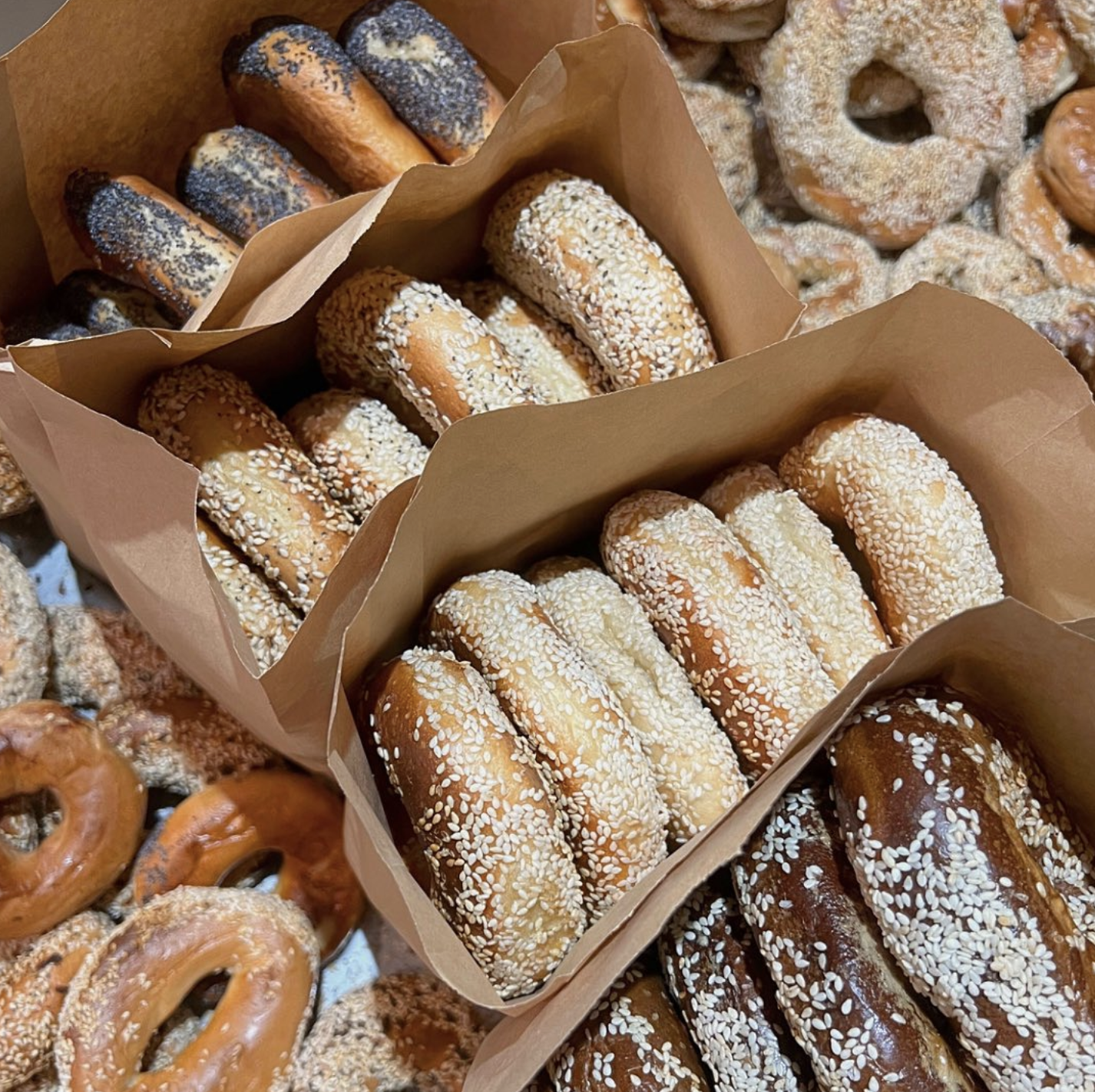 Paper bags of sesame and poppy bagels from Bagels on Fire